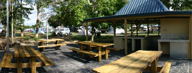 Cairns Holiday Park - Cairns: Camp kitchen and BBQ area with view of powered and camping sites in the background.