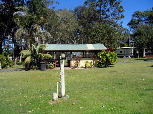 Arrawarra Beach Holiday Park - Arrawarra: Powered sites for caravans with camp kitchen in background.