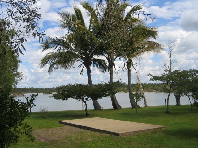 Boonooroo Caravan Park - Boonooroo: Powered sites for caravans with water view and palm trees