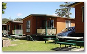 Joalah Holiday Park - Durras North: Waterfront and Waterview Deluxe Cabin with BBQ in foreground.