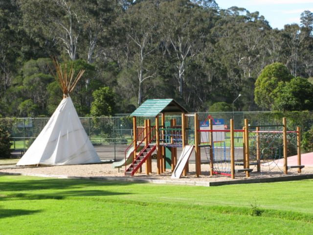 Discovery Holiday Park - Eden: Play area for children with tennis courts in the background