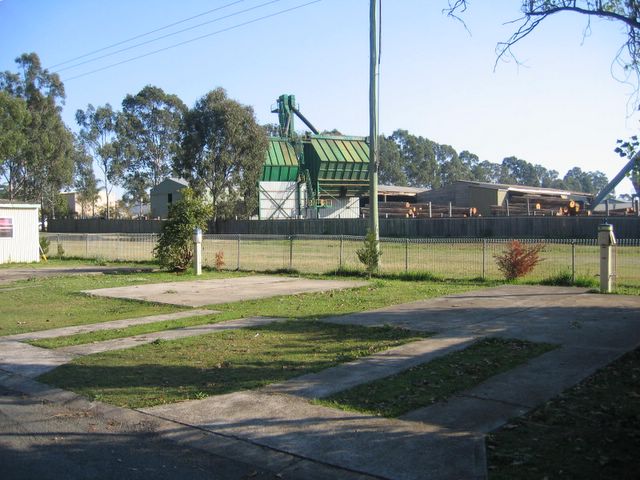 Glenwood Tourist Park & Motel - Grafton: Powered sites for caravans with timber mill in background