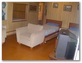Riverlands Caravan Park and Wombat Cafe - Gunderman: Cabin lounge room showing two single beds