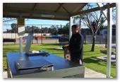 BIG4 Yarrawonga-Mulwala Lakeside Holiday Park - Mulwala: Modern Camp Kitchen and BBQ area with tennis courts in the background.