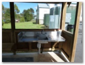 Waratah Caravan Park and Camping Ground - Waratah: Camp kitchen. Amenities are in the green water tanks behind.